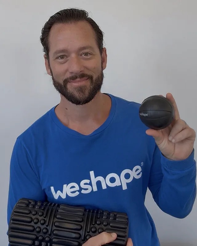 Coach Tyler, founder of WeShape, holding the WeRoll roller and WeRelease ball